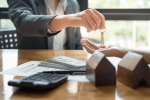 Tenant screening and rental approval concept with landlord giving keys and lease agreement on table